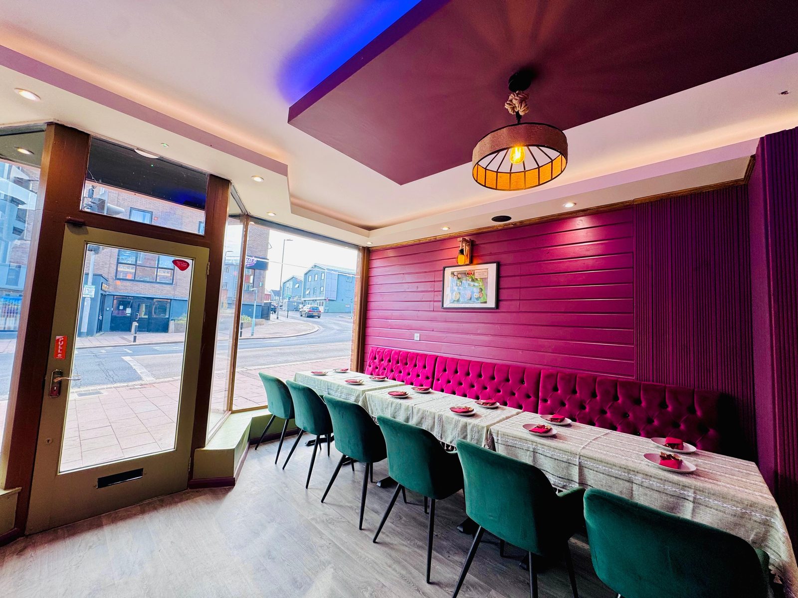 The dining room at InDish: green velvet chairs and magenta banquette by the South Street window, Exeter
