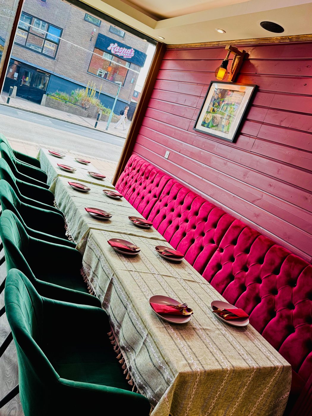 Inside InDish: magenta velvet banquette and green velvet chairs set for dinner, South Street, Exeter